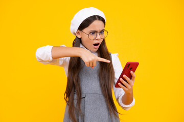 Angry face, upset emotions of teenager girl. Mobile online shopping. Funny teen child girl paying with phone, texting and chatting on smartphone.