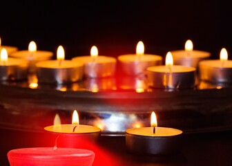 Burning candle light on black background