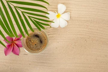 Zelfklevend Fotobehang Palm leaf with plumeria flowers and a cup of coffee on sand background © Phinyaphat Ritthiruangdet/Wirestock Creators
