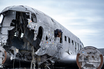 girl tourist leaned out of the porthole of damaged dc 3 plane in iceland black beach