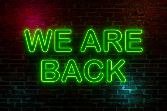 We Are Back, Neon Sign. Brick Wall At Night With The Text 