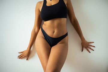 Cropped view of sexy african american woman in underwear touching wall.