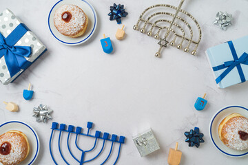 Jewish holiday Hanukkah frame border background with traditional donuts, menorah and gift box. Top...