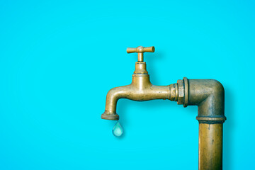 Old water brass faucet isolated on solid color background with the last potable drop of water -...