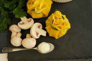 Pancakes. Yellow stuffed bliny with mushrooms and sour cream. Light background. Beautiful and...