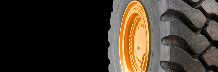 New large tire of an heavy industrial machinery with a bolted yellow wheel rim - image with copy...
