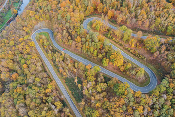 Bird's-eye view of a winding road in Taunus/Germany through an autumn-colored forest