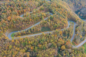 Obraz premium Bird's-eye view of a winding road in Taunus/Germany through an autumn-colored forest