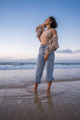 Cheerful woman with tanned skin looking at the distance and enjoying of the ocean