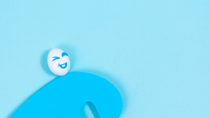 An egg with a cheerful expression rushing on a wave of good luck. The concept of a successful life position of an optimist. Blue background.