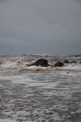 Large waves crashing onto the beach during a storm with a dramatic sky background. Taken in Cleveleys Lancashire England. 
