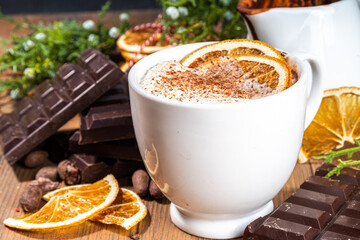 Orange hot cocoa drink. Homemade winter Christmas dark spicy hot chocolate with dried orange, with chocolate and orange slices on wooden cozy background