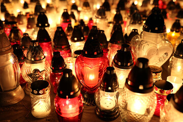 Znicze na grobie osoby bliskiej świeci podczas święta zmarłych wieczorem. Światło. - obrazy, fototapety, plakaty