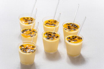 passion fruit mousse, small glass with passion fruit mouse on white background
