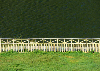 White bamboo fence and green grass background. Beautiful bamboo fence.
