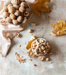 Peanuts and walnuts on a canvas background arounded autumn leaves. Top view  - 543000552