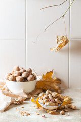 Still life with peanuts and walnuts on a light autumn background. Copy space - 543000596