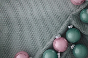 Beautiful Christmas balls in soft pink and mint colors on a knitted fabric.