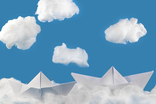 Paper boat on the waves of cotton wool. Cotton clouds