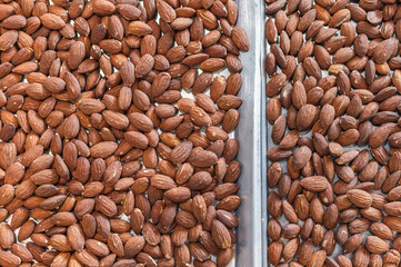 Tray full of brown whole roasted almond nut.
