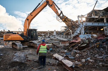 Fototapeta premium Excavator destroyer removes debris under worker control
