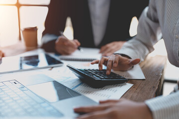 Business people in a meeting and using a calculator to calculate, plan, analyze, create graphs and charts to show business growth to plan new business expansions in the future.