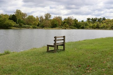 Fototapeta premium The empty wood bench by the lake in the countryside.