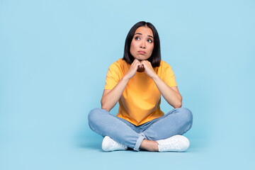 Fototapeta na wymiar Full body photo of lovely young girl chinese sit floor sad psychotherapy dressed stylish yellow look isolated on blue color background
