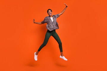 Fototapeta na wymiar Full length body size view of attractive cheerful trendy girl jumping having fun isolated over vivid orange color background