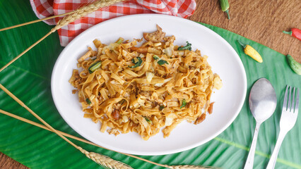 Concept of tasty eating with bowl of fried flat rice noodles or char kway teow or kwetiau. ready to eat, selected focus