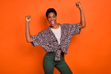 Photo of excited crazy person raise fists celebrate success shout yeah isolated on orange color...