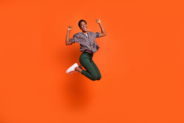 Fototapeta na wymiar Full length body size view of attractive cheerful trendy girl jumping rejoicing isolated on bright orange color background