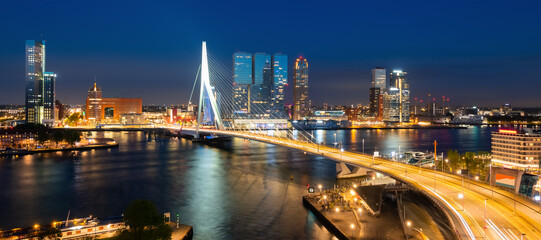 Nighttime panorama of Rotterdam Netherlands with skyline, modern buildings and iconic bridge....