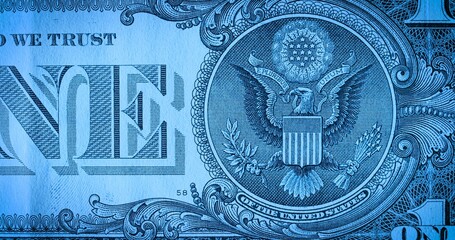 Macro shot of the back side of a one dollar bill with stars and an eagle in blue soft light. US paper banknote. American money. Banking, finance, business.