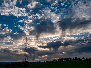 Strommasten und dunkler Wolkenhimmel