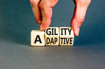 Agility and adaptive symbol. Concept words Agility and Adaptive on wooden cubes. Beautiful grey table grey background. Businessman hand. Business agility and adaptive concept. Copy space.