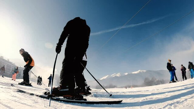 Kabinkov ski lift cable car cabins at winter resort Bansko. People take ski lessons from instructor, slow motion