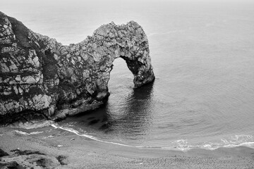 Grayscale of Durdle Door in the sea in Dorset, England