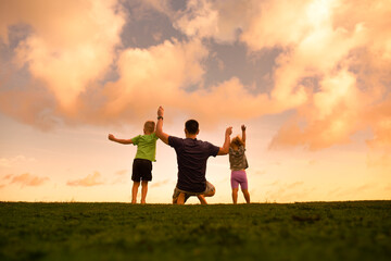 Happy father son and daughter with arms up outdoors.  Fatherhood, and family happiness concept.	
