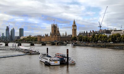 Aerial shot of ships sailing on the river Thames with Big Ben and other buildings on the background