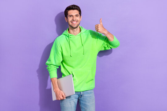 Photo of young junior java it developer programmer man hold his new apple macbook thumb up recommend advert isolated on violet color background