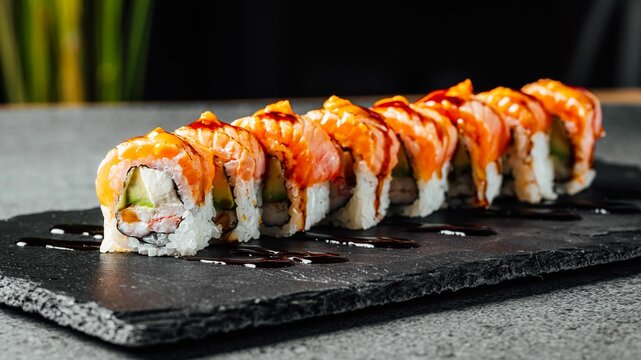 Closeup of a set of delicious fresh sushi rolls served on a black board