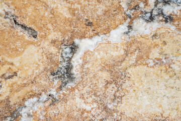 Macro shot of granite or marble stone structure with brown white marbling and spots. Marble stone surface with texture pattern. Marble countertop, tile, path, wall. Facing stone with marbled structure