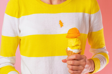 Spilling ice cream on clothes. Ruining clothes. A girl's hand holding a ice cream cone with three...