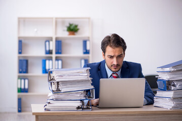 Fototapeta premium Young male employee and too much work in the office