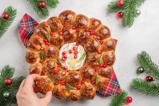 Bread Christmas wreath with cheese topped with rosemary and red pomegranate. Festive monkey bread