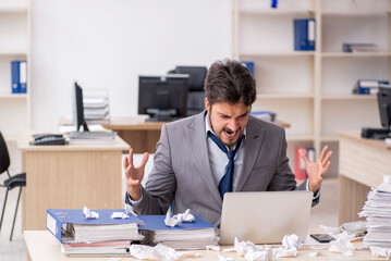 Young male employee and too much work in the office