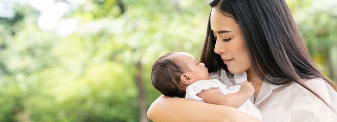 Closeup portrait of beautiful young asian mother day kissing her newborn baby. Healthcare and...