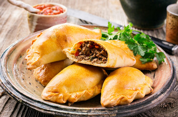 Traditional Spanish baked empanada de carne with minced meat and vegetable served as close-up on a...