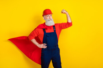 Photo of confident strong age man wear overall uniform red hard hat cape rising fist isolated...